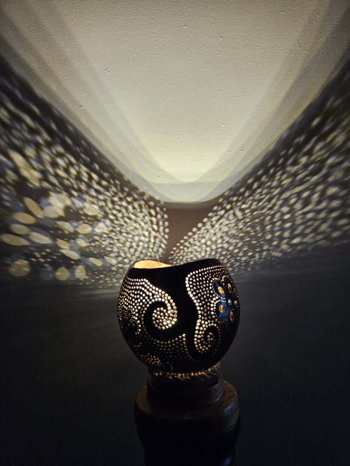 Decorative candle holder casting a patterned shadow on a wall