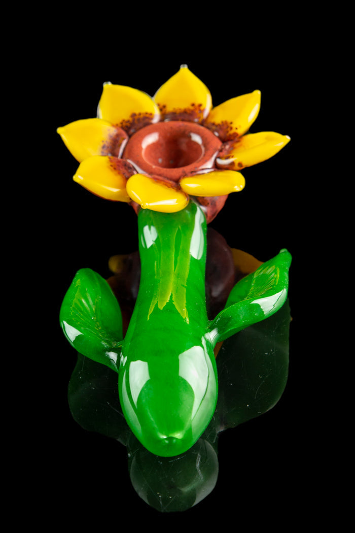 A vibrant green and yellow glass cannabis pipe shaped like a blooming flower.