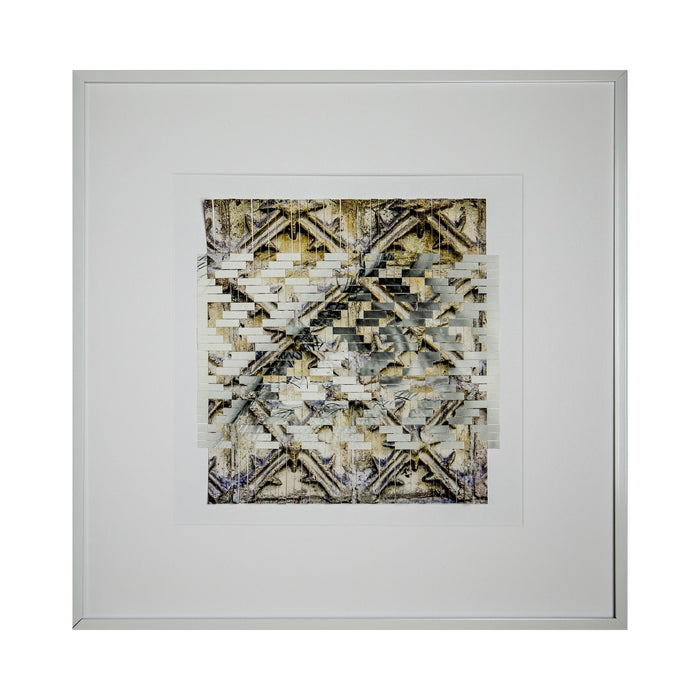 The artwork 'Indirection' by Kiana Honarmand features an intricate geometric pattern of hand-cut and woven giclee prints. The composition displays overlapping diagonal lines creating X-shaped motifs in muted gold, beige, and gray tones. The textural layering effect produces a complex, abstract design with weathered, vintage-like qualities, framed in crisp white matting and a minimalist silver frame.