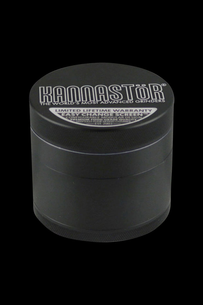 A close-up, angled view of the Kannastor Multi Chamber 4pc 2.2" Grinder, showcasing its metallic finish and multi-tiered construction.