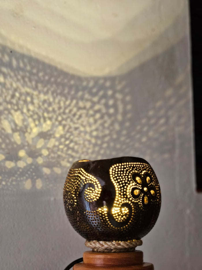 Decorative lamp with intricate patterns casting a shadow on a wall