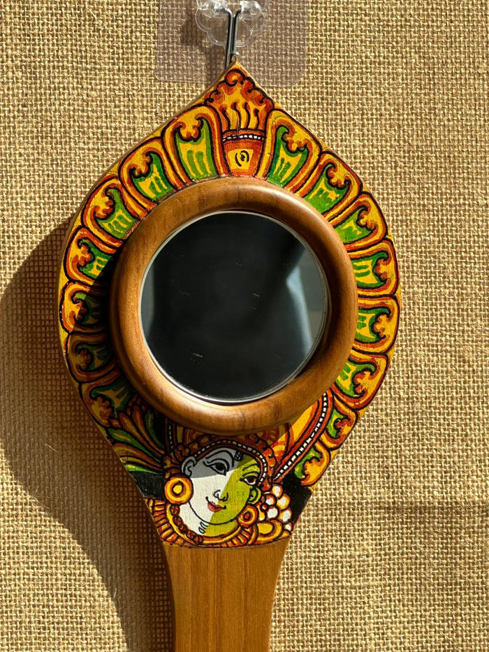Decorative hand mirror with colorful patterns on a beige background