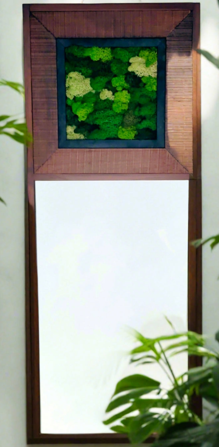 A rectangular mirrored wall art piece with a green mossy panel set within a wooden frame, accompanied by a decorative vase with a green floral pattern.