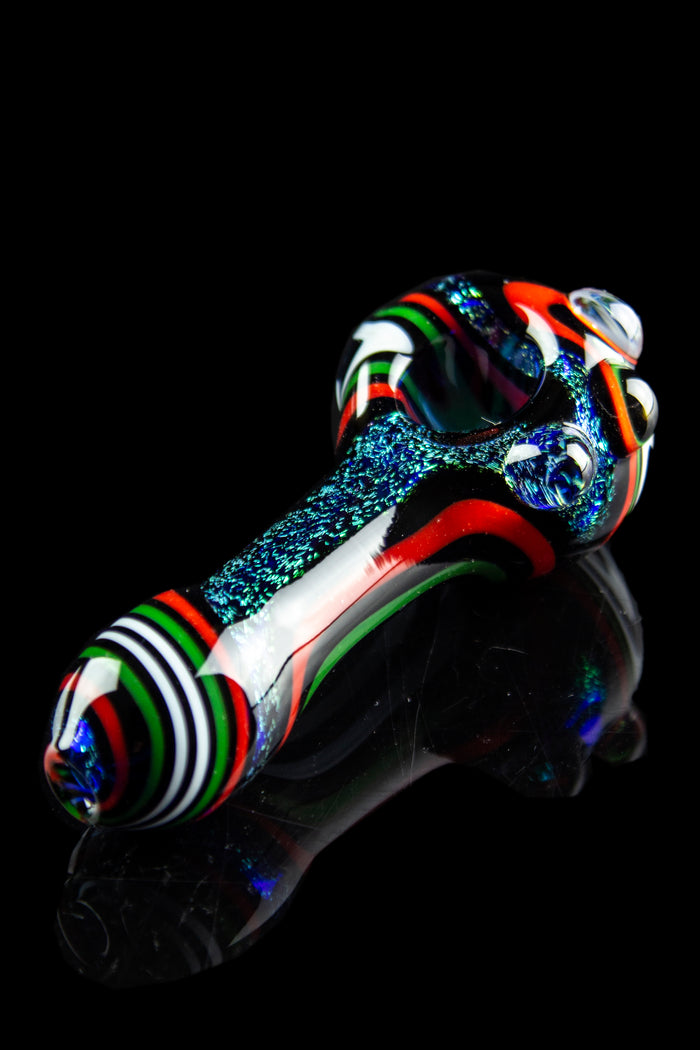 Hand-blown glass pipe with vibrant stripes and speckled accents, isolated on black.
