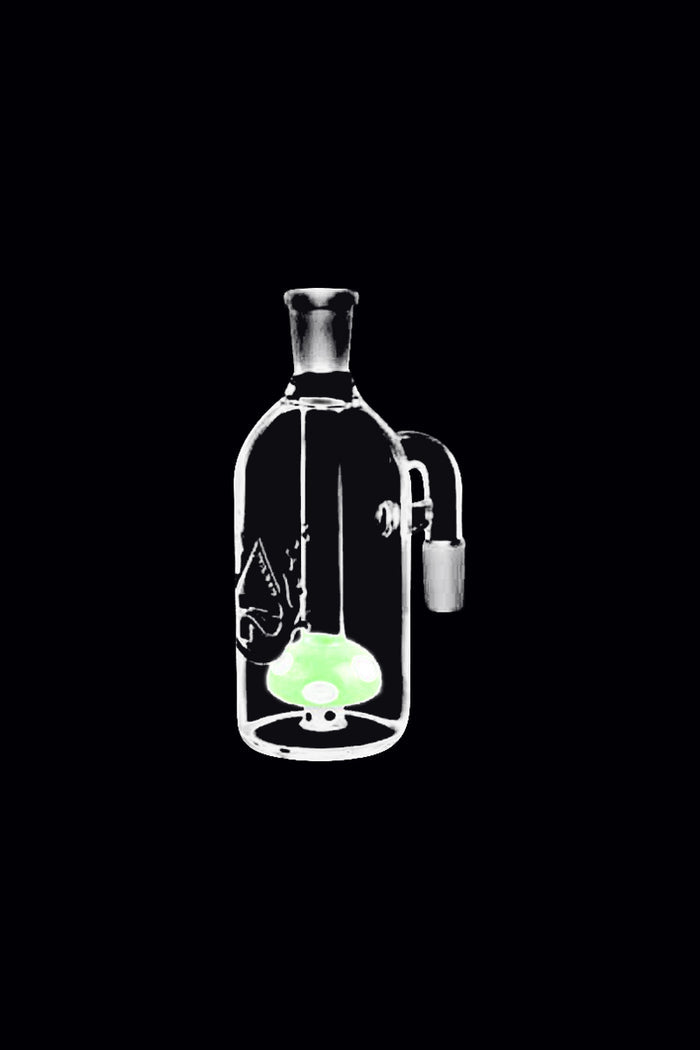 Center-framed front view of the Pulsar Mushroom Perc Ash Catcher showing a clear glass chamber with a glowing green mushroom perc inside against a black background.