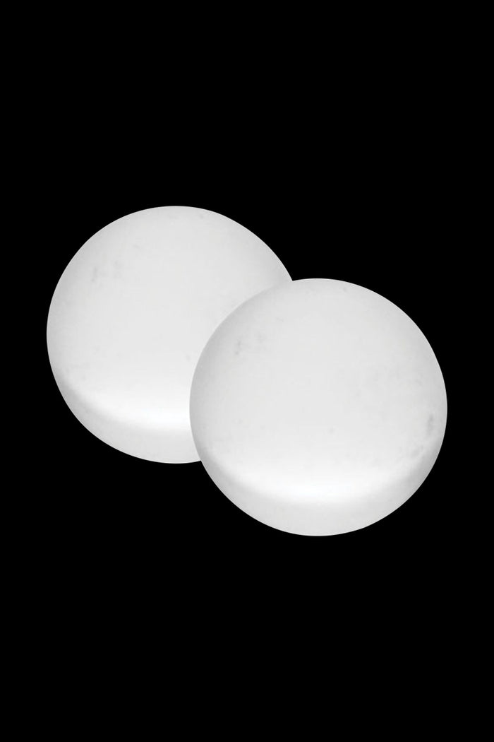 Close-up of two smooth white Pulsar Quartz Terp Beads - 2 Piece Set shown from a slightly elevated angle against a black background