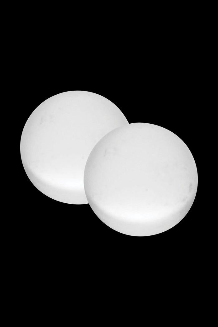 Top-down view of two white Pulsar Quartz Terp Beads - 2 Piece Set resting against a black background, slightly overlapping.