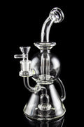 Clear glass water pipe (rig) with intricate bubbler design, isolated on black.