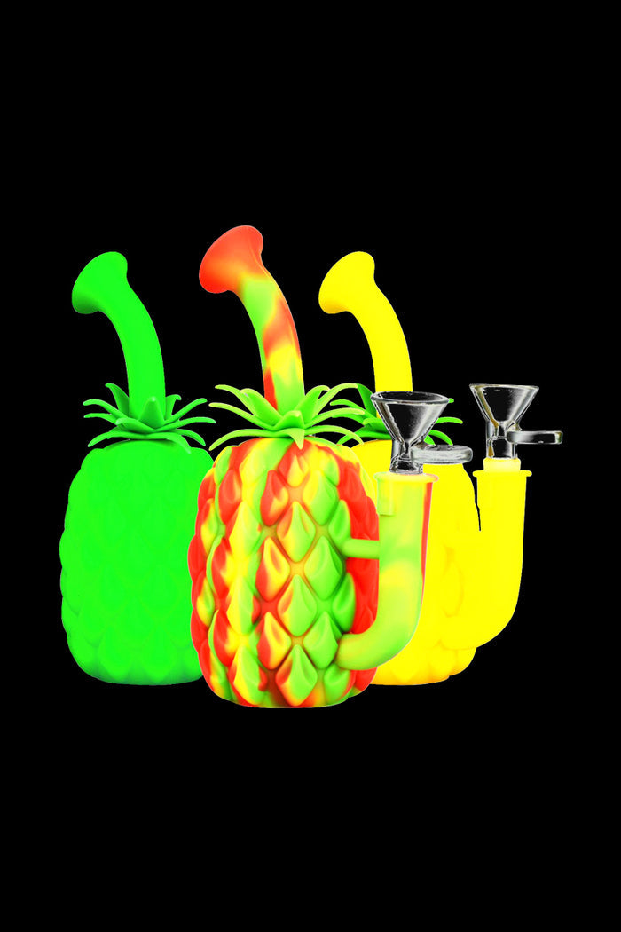 Front-facing trio of The Pineapple Bong - Silicone Bong with Glass Bowl in neon green, yellow, and red-green swirled pineapple shapes against a black background.
