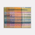 The artwork 'Untitled 155' by Victoria Manganiello features an abstract grid pattern in muted pastel colors, combining blues, pinks, oranges, and yellows. The woven textile piece creates a plaid-like effect with overlapping translucent stripes, showcasing natural and synthetic fibers with a watercolor-like quality in a 40x52 inch format.