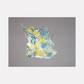 The artwork 'Untitled 172' by Victoria Manganiello features an abstract composition of intertwining fibers in yellow and light blue hues. The textile piece displays flowing, organic patterns with wispy strands creating dynamic movement against a gray background. Natural and synthetic fibers are woven together in a 9x9 inch format, showcasing a delicate interplay of textures and dyes.