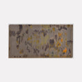 Untitled 8 by Victoria Manganiello features abstract patterns in muted gray tones with scattered golden yellow and orange accents, created using natural and synthetic fibers. The composition suggests a watercolor-like effect with organic shapes flowing across the 58x30 inch textile surface, blending dyed materials in a contemporary abstract style.